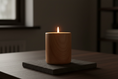 Load image into Gallery viewer, A lit wood-grain ceramic candle vessel glowing gently on a table in a dimly lit room, evoking rest, reassurance and quiet closeness.